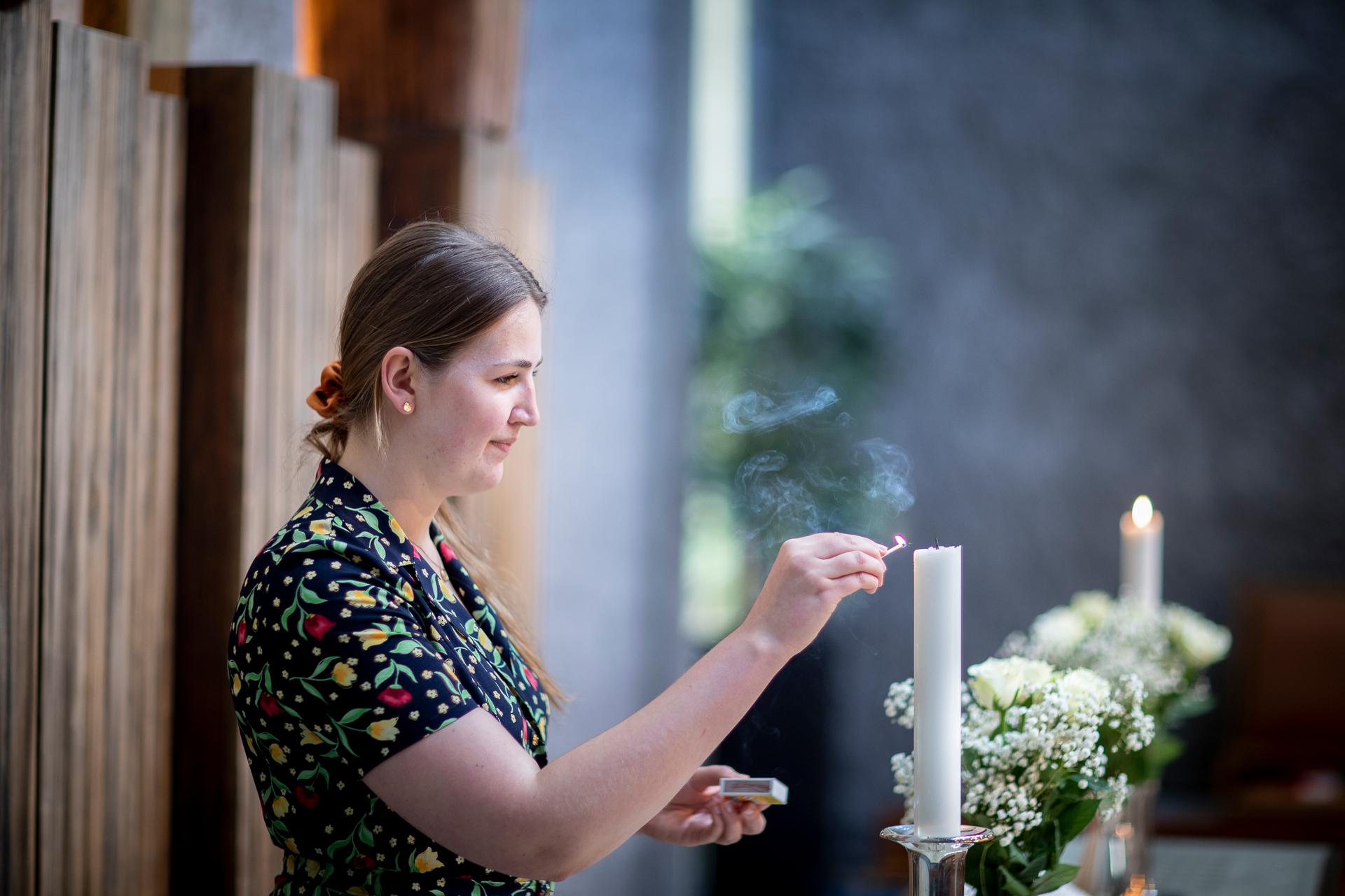 Kvinne tenner lys på alter